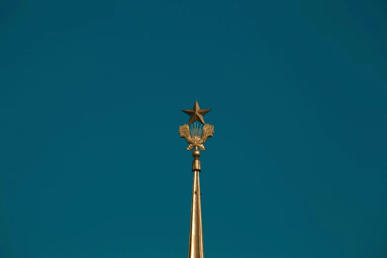 the large statue of an eagle and a star is on top of a pole