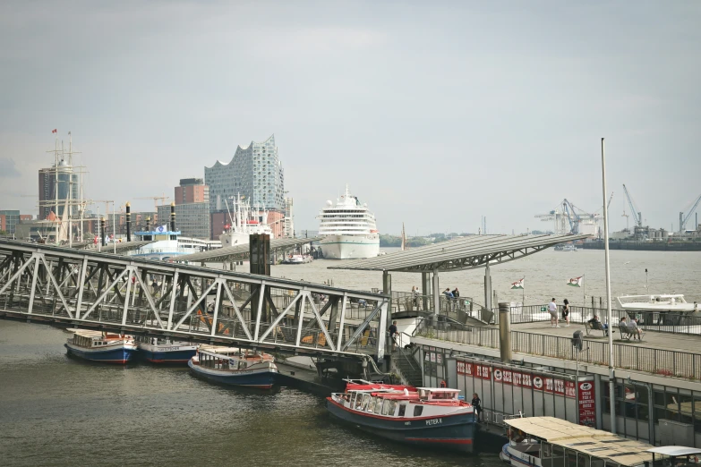 a city with boats in the water and people walking across a bridge