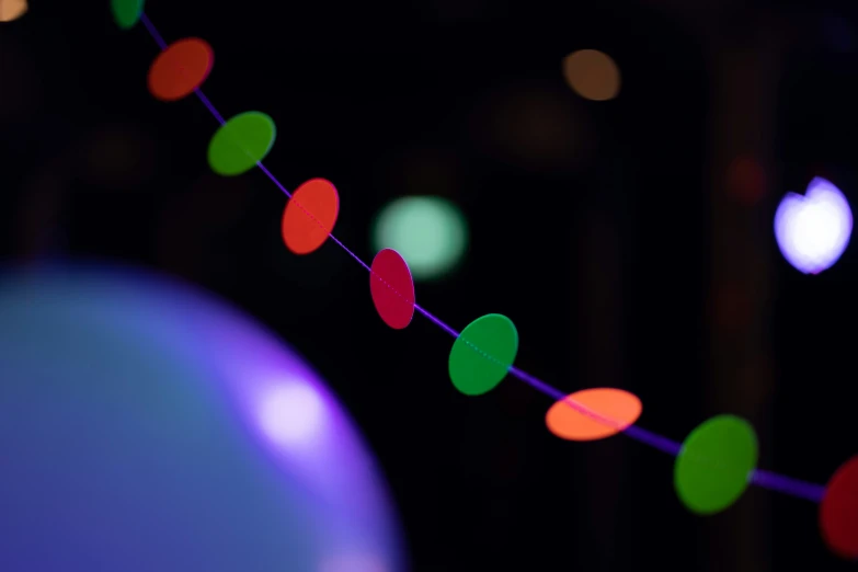 a line of multi colored lights hanging from strings