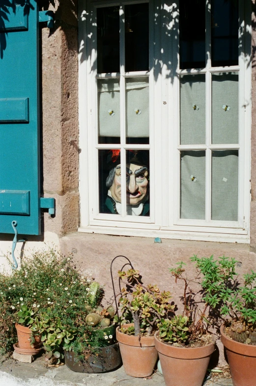 the planters are outside of a window with a face in it