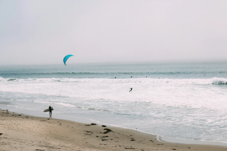 the man is on the beach flying his kite