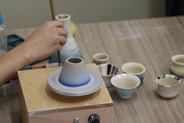 the pottery is being made with a brush