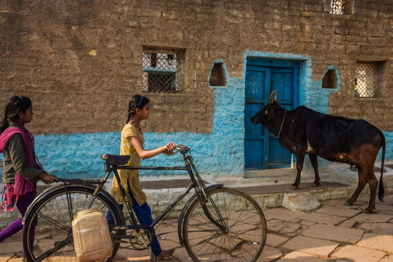 a woman with a bike that has a bull standing on it