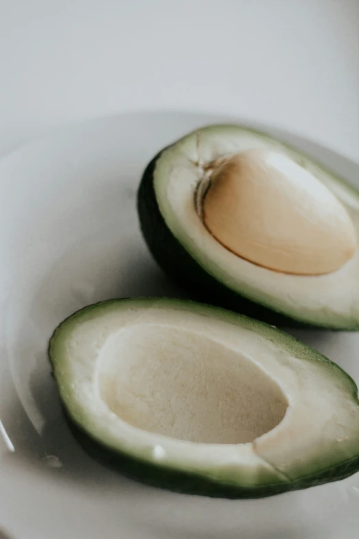 an avocado sliced into pieces sitting on top of a white plate