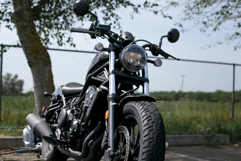 the motorcycle is parked outside next to a tree