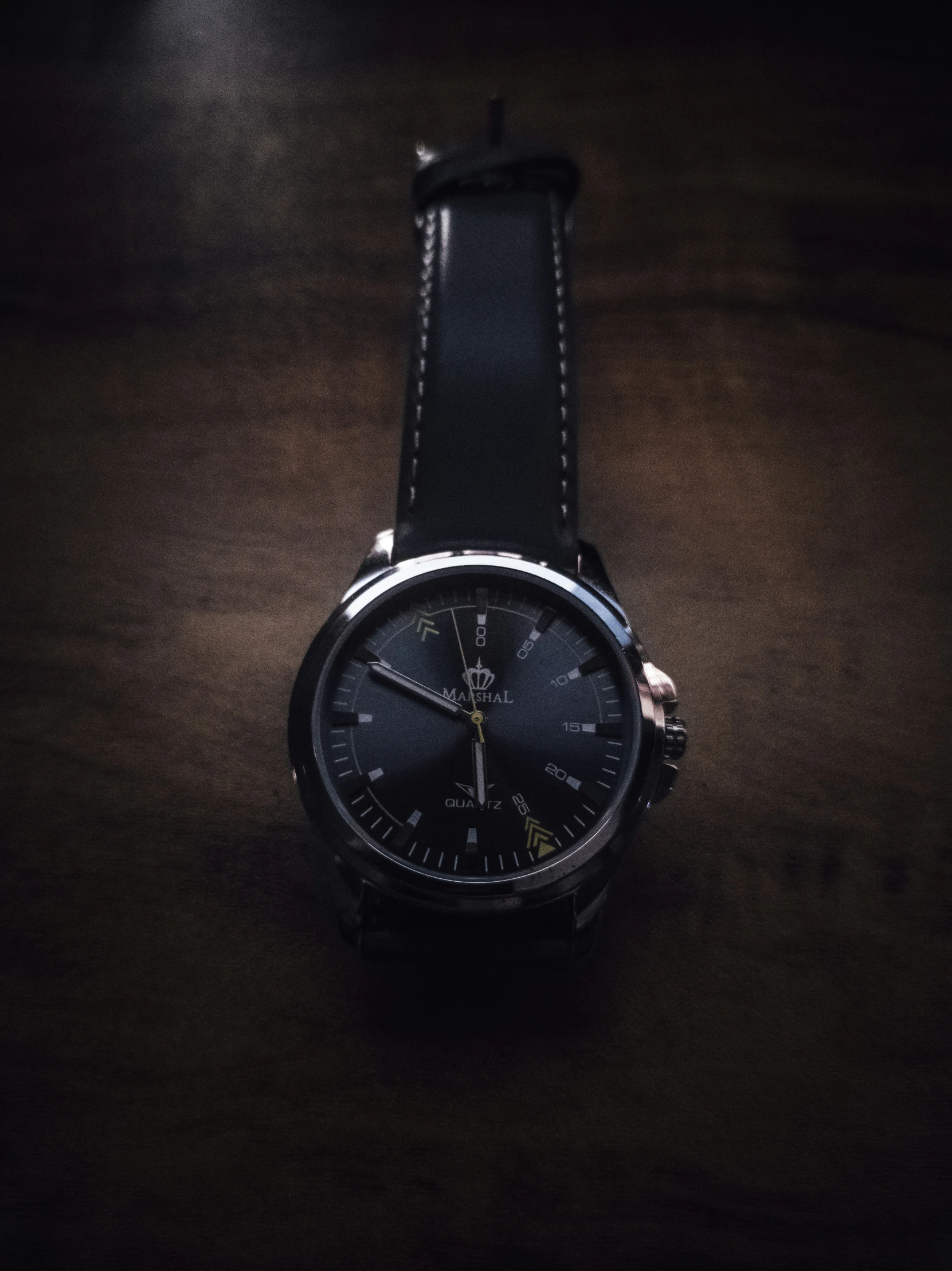 a watch is shown in the dark with a leather strap