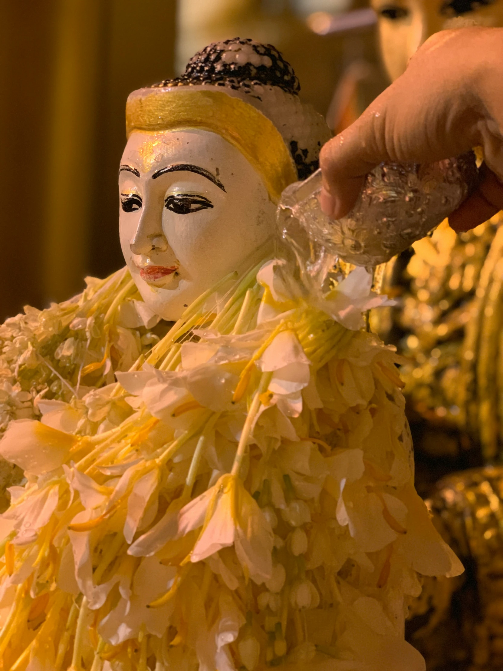 a close up of someone holding a face mask over flowers