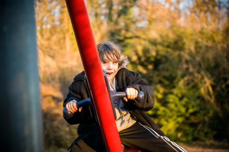 a man leaning on top of a red pole