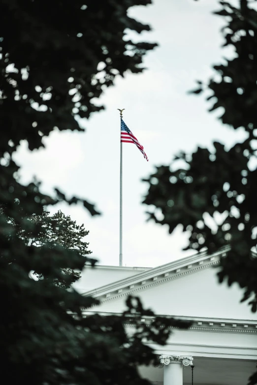 an american flag on the top of a white building