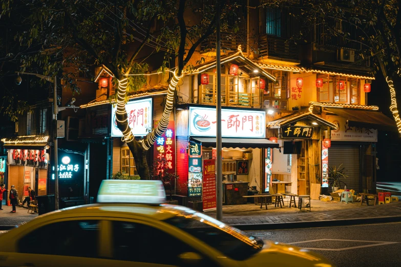 a small storefront at night on a street corner