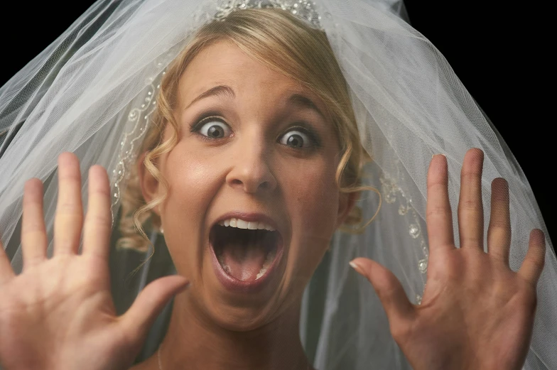 the woman is surprised while holding up her hands