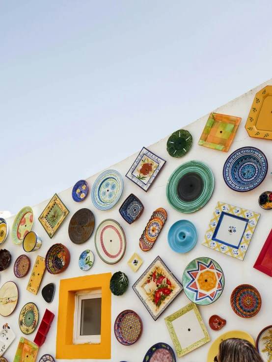 some plates and bowls hanging up against a wall