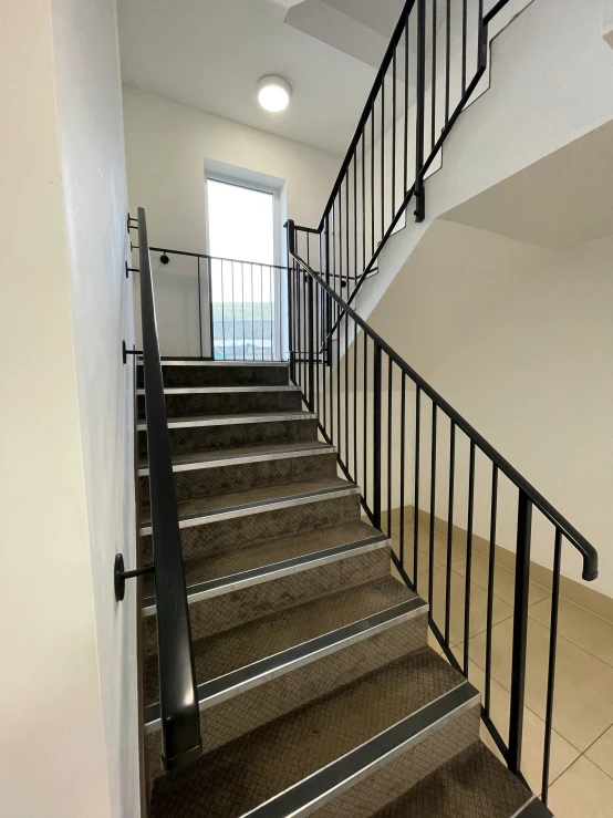 a stairwell with gray carpet and metal railings
