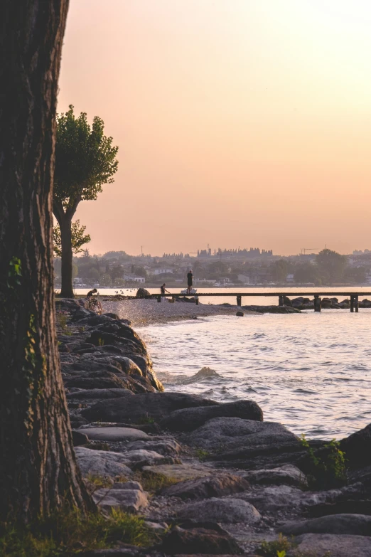 a person walking across rocks to the water