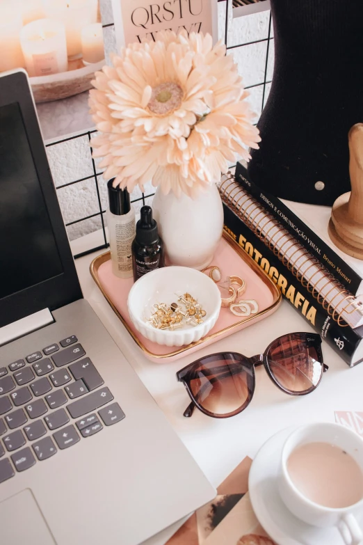 a desk containing sunglasses, a vase and books