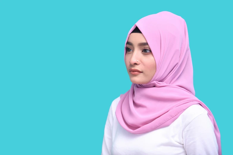 a woman with a pink headscarf looks away
