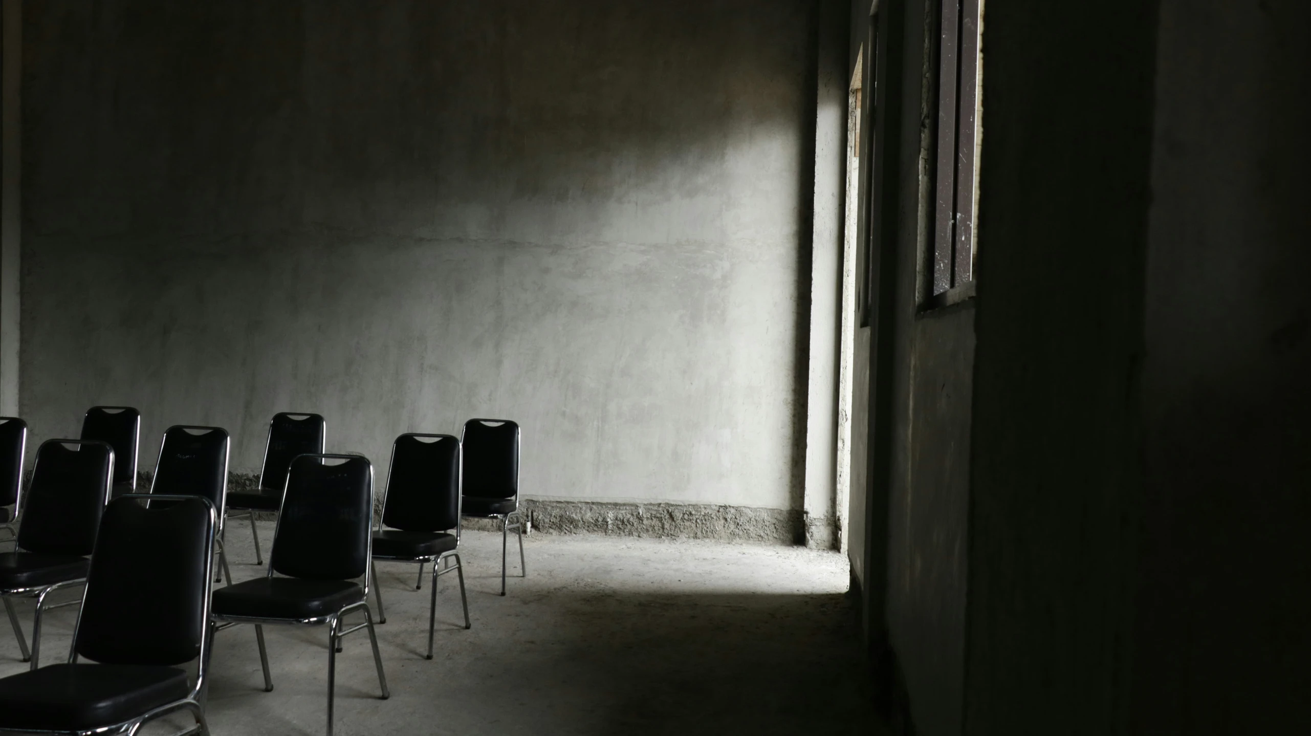 an empty row of chairs lined up against a wall