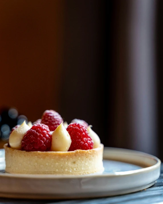 a cake is topped with raspberries on a white plate