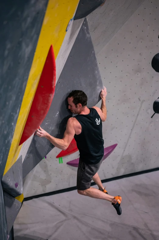 a man that is standing on the side of a climbing wall