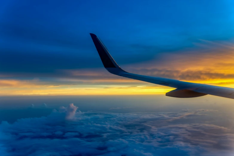 an image of a wing and clouds at sunset