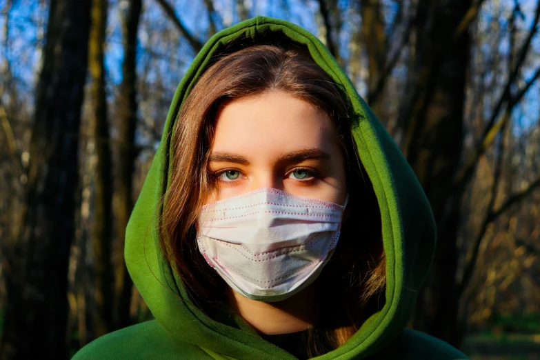 a person wearing a face mask with trees behind