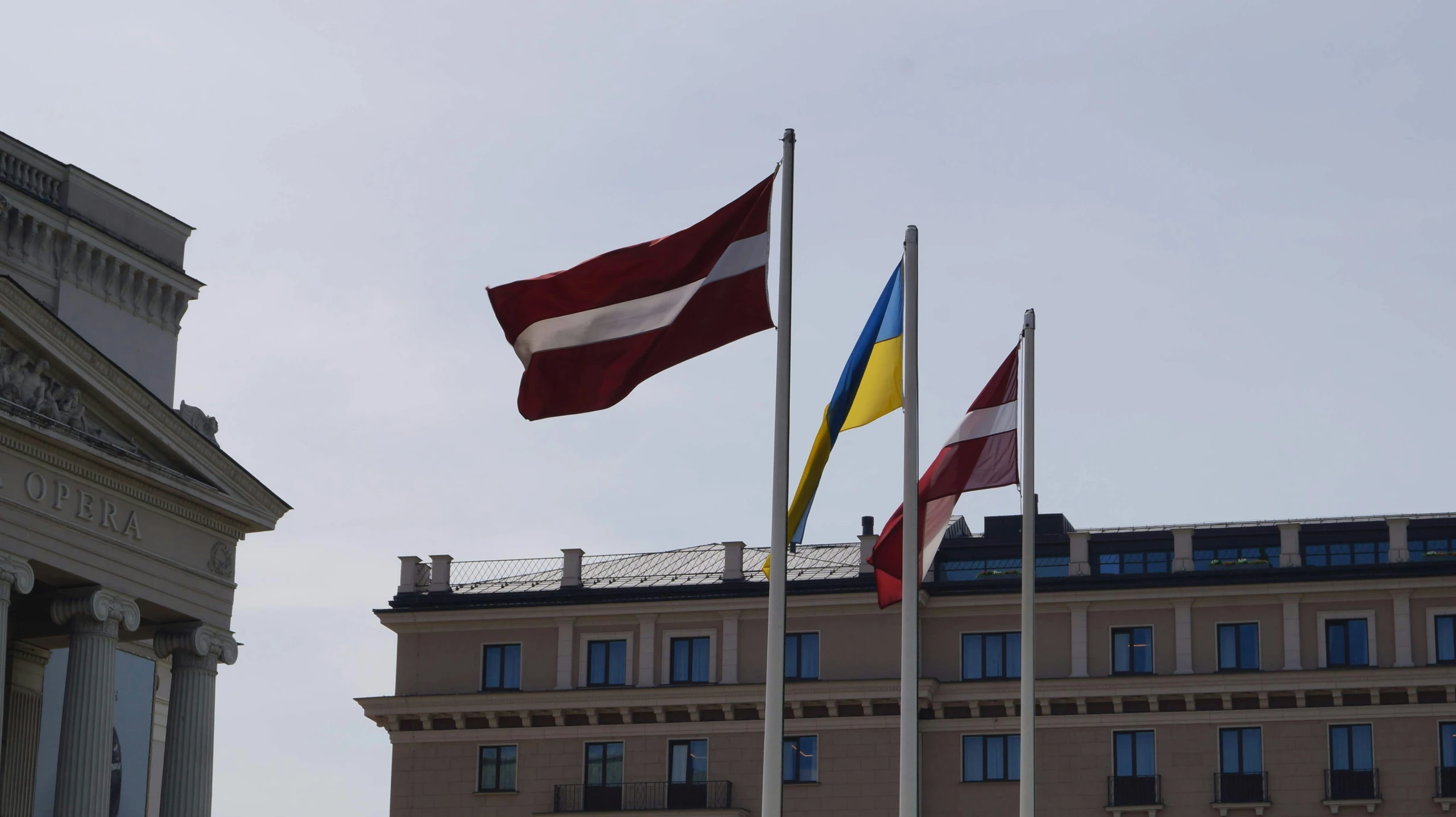 several flags fly in front of a building