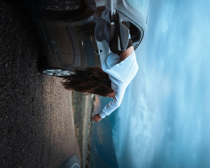 a woman holding onto the trunk of her car