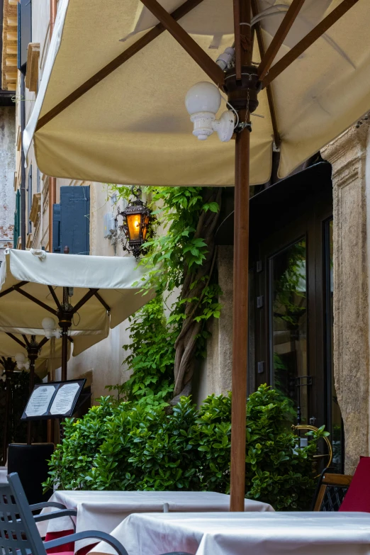 a patio covered with tables and umbrellas with red chairs