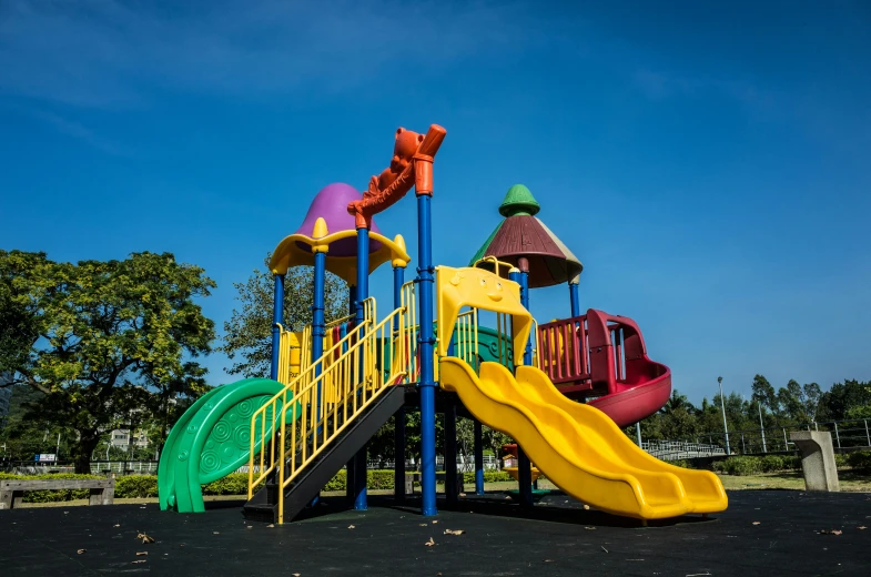 a playground with yellow, green, blue and purple slide