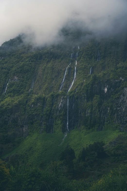 the top of the mountain that is covered with clouds