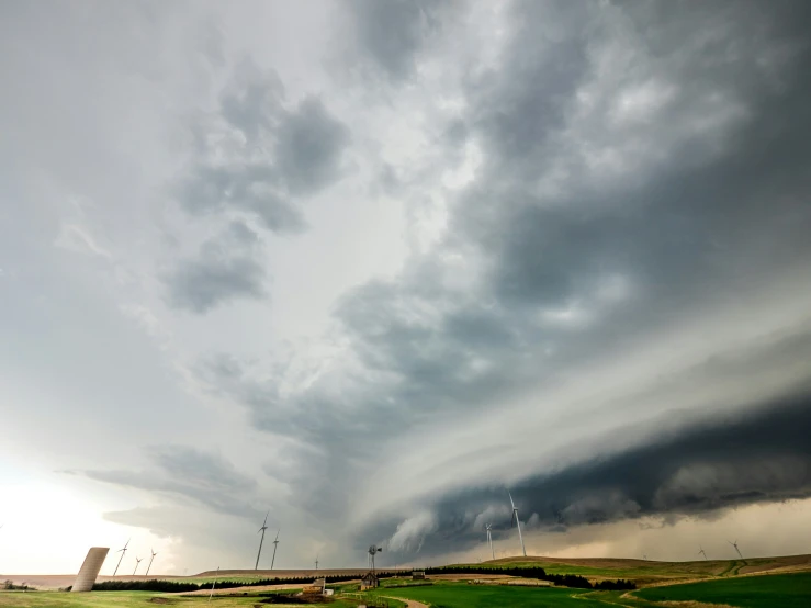 a large storm cloud rolling across a large field