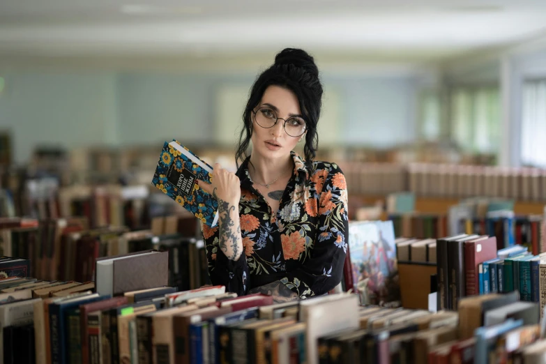 a woman reading in the liry while sitting at her desk