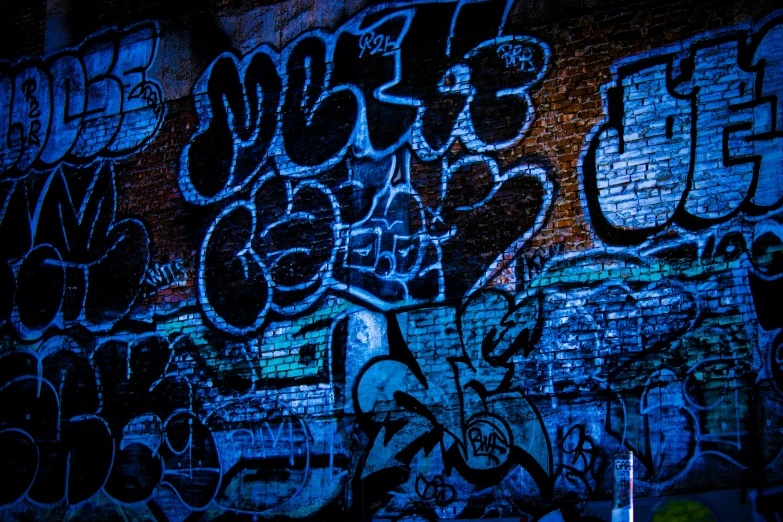 graffiti covered brick wall and sidewalk light at night