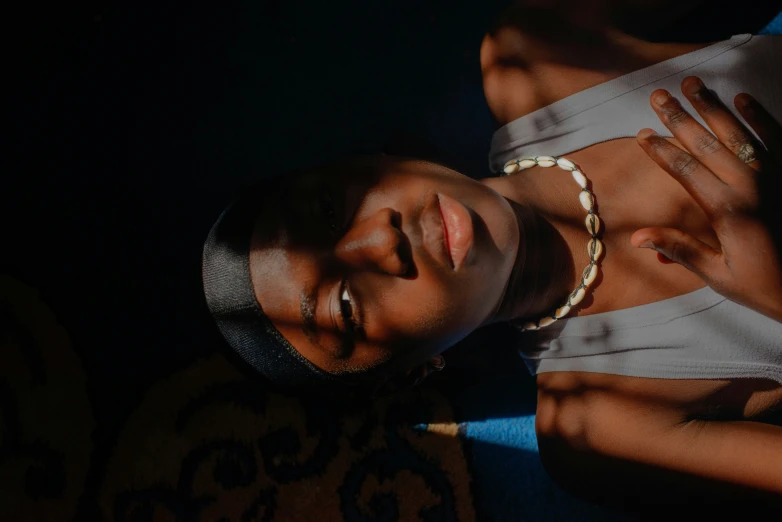 a woman wearing necklaces while laying down