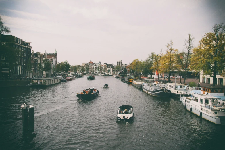 boats traveling down a river near many buildings