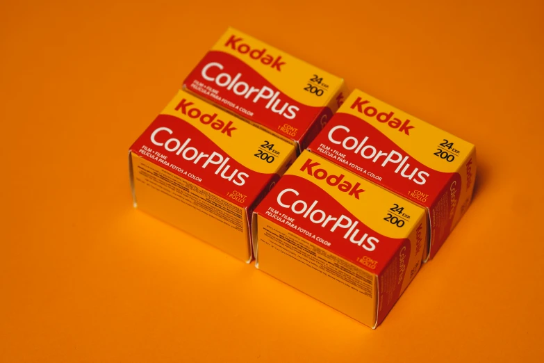 two boxes of kodak klonisk are shown on a orange surface