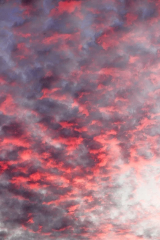 a red and white cloud in a blue sky