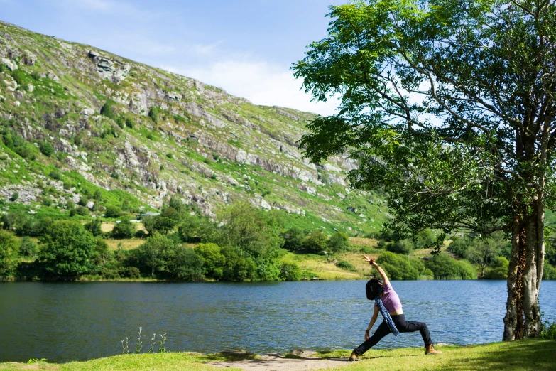 a person in a yoga pose by the water