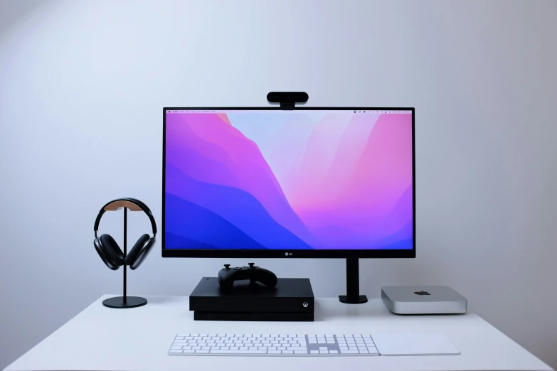 a white desk with a computer on it and some headphones