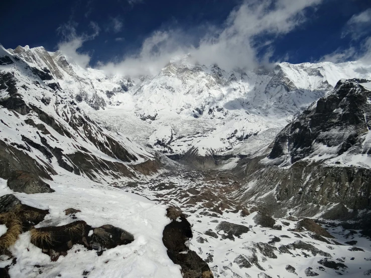 a wide and rocky mountain range is covered in snow