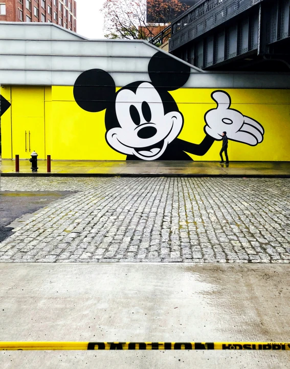 a painting of a mickey mouse with a street marker pointing to it