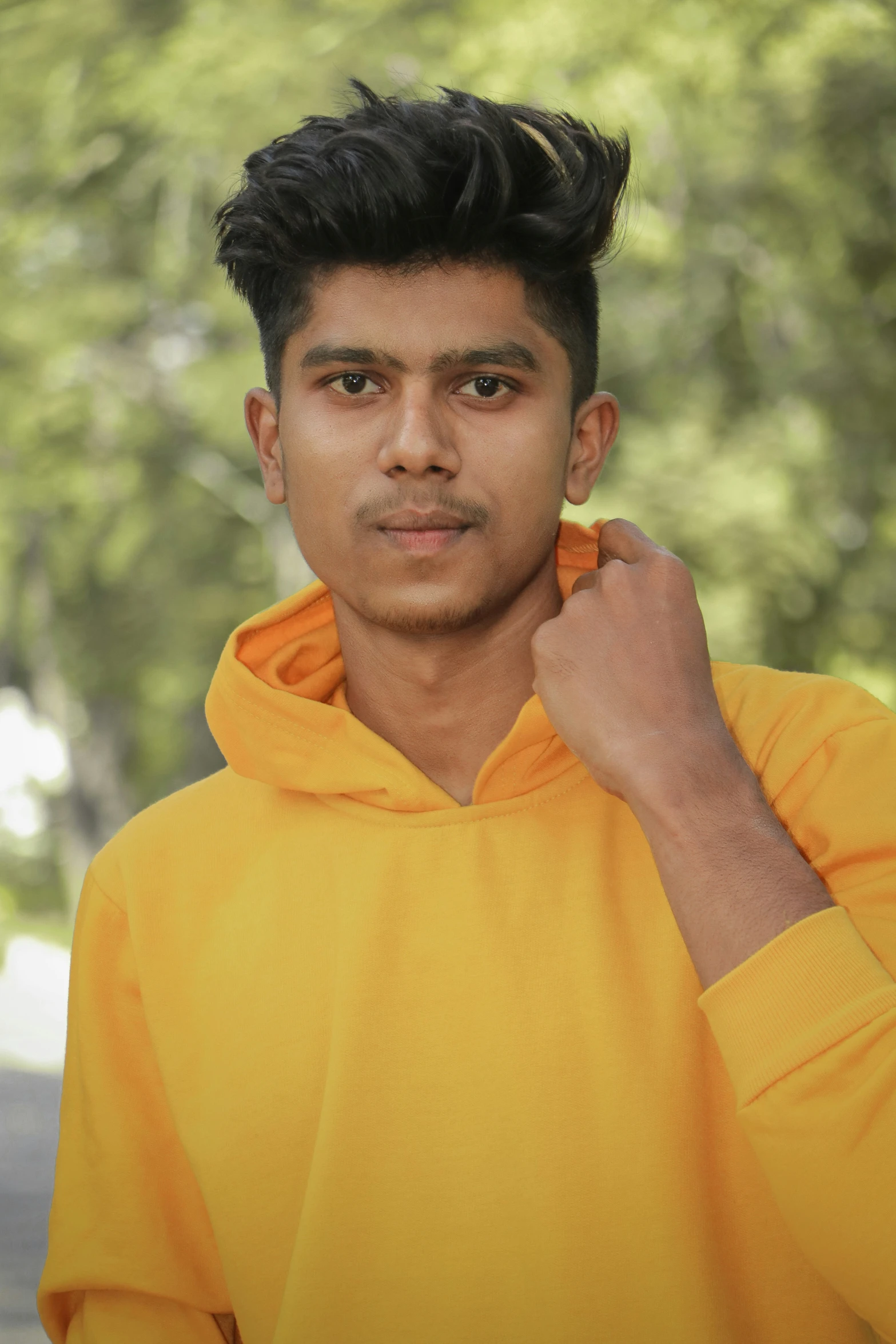 an image of a man in yellow hoodie posing for the camera