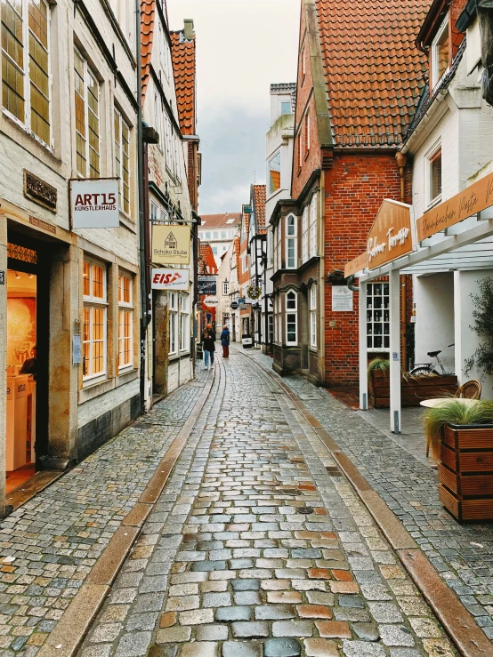 a person walking down an old cobble stone street