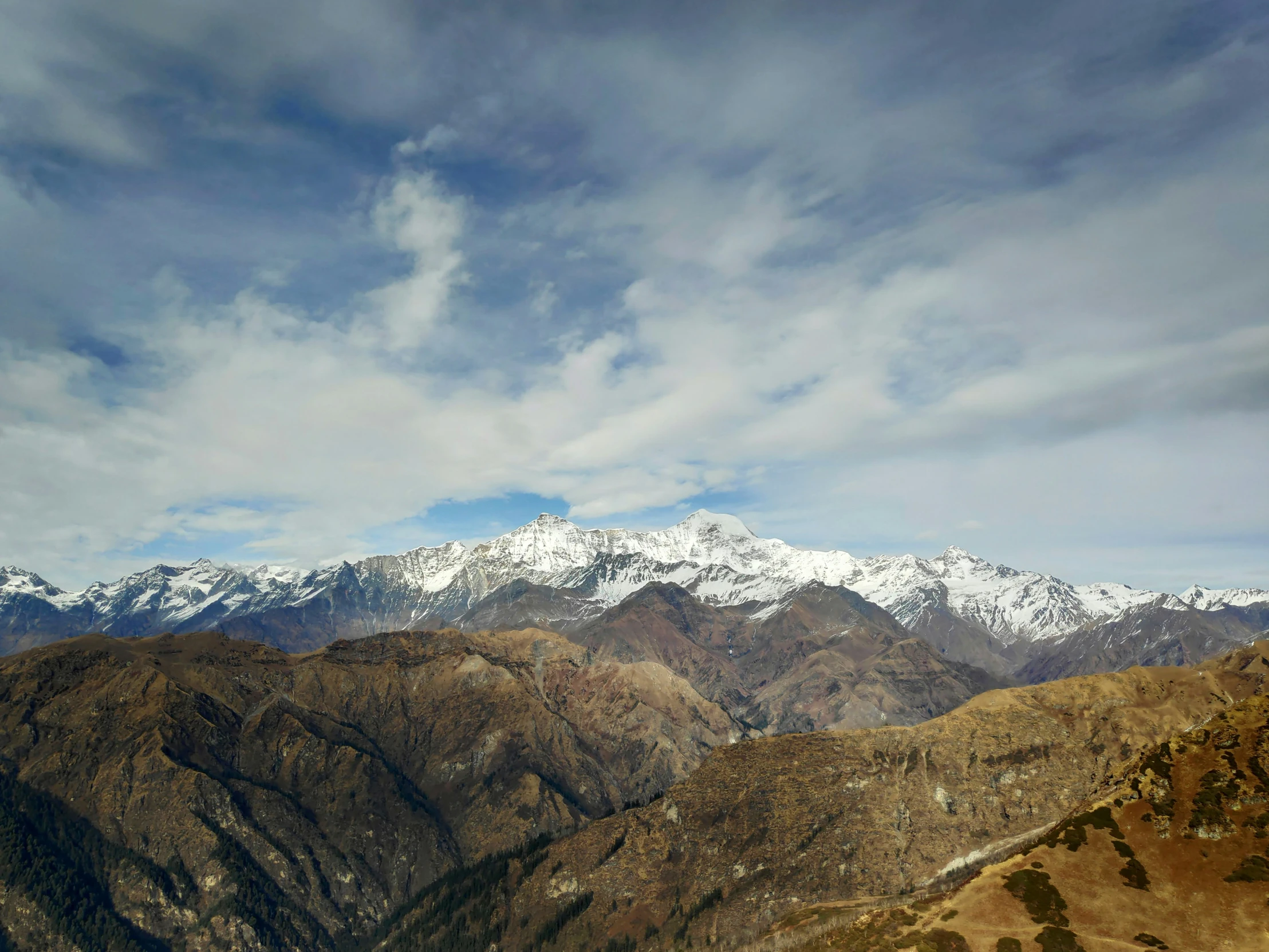 snow capped mountain range viewed from a cliff