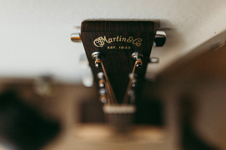 a brown and white guitar with the top part showing the strings