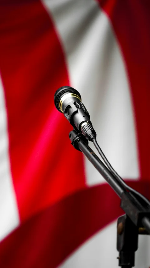 a black and silver microphone with a red and white flag