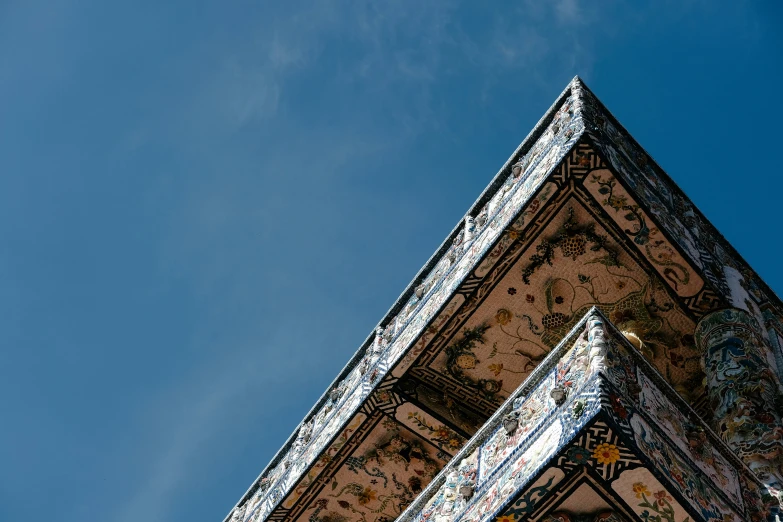 an upward view of a building that has intricate mosaic on it