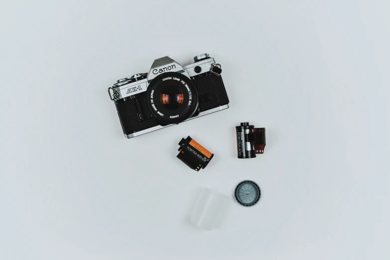 camera, battery and batteries on white surface