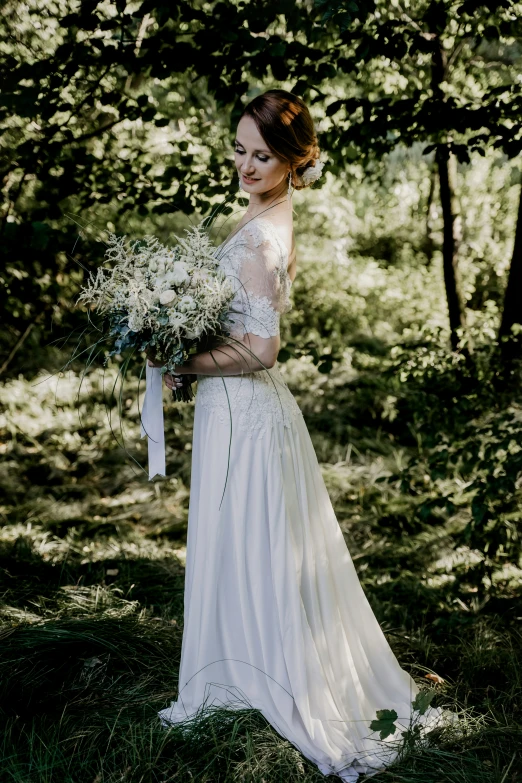 a bride is posing for a po in the woods