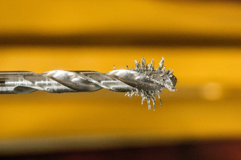 a small silver object on a yellow surface